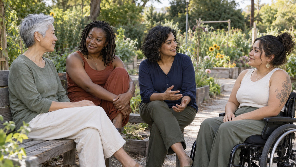 Four women share a supportive conversation for National Coming Out Day in a community garden