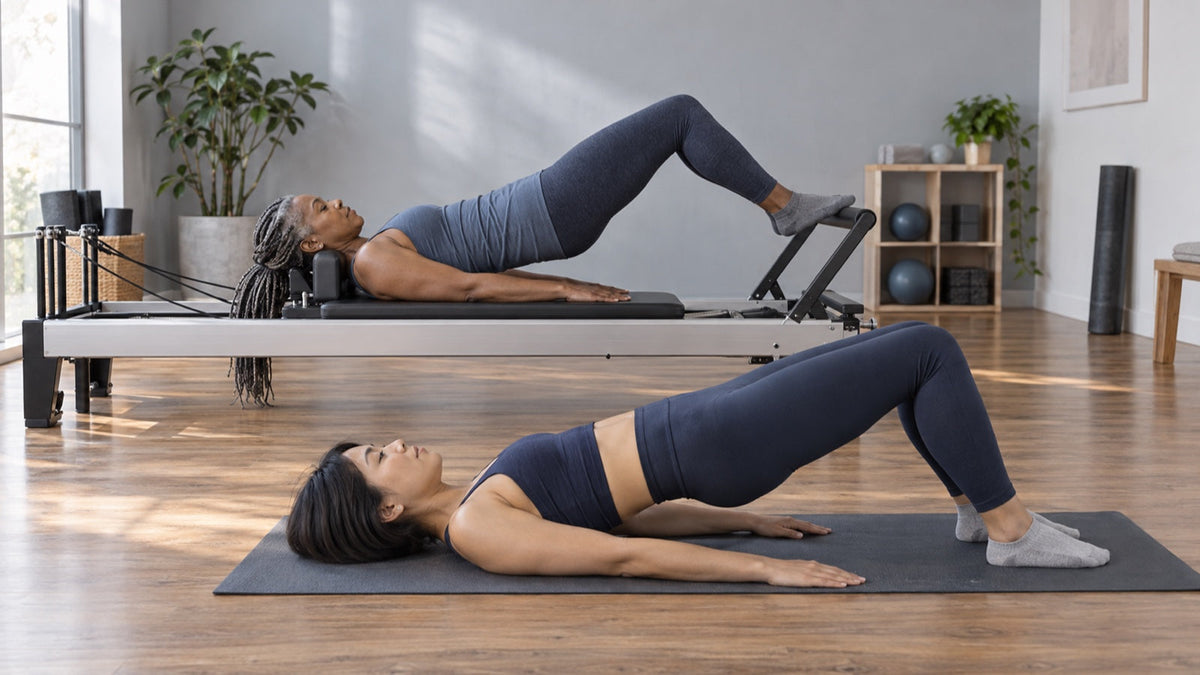 Two women compare mat and Reformer Pilates movements in a calm studio