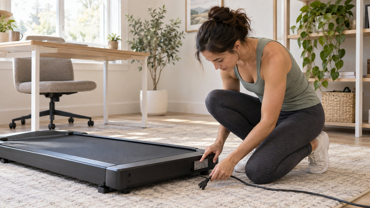 Woman checks the model label on an unplugged walking pad in a bright home office